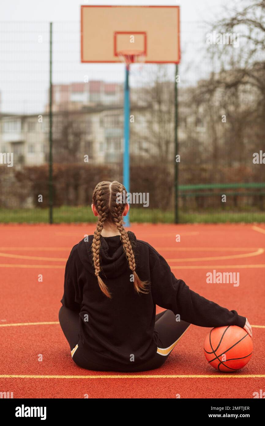 adolescent posant terrain de basket-ball Banque D'Images