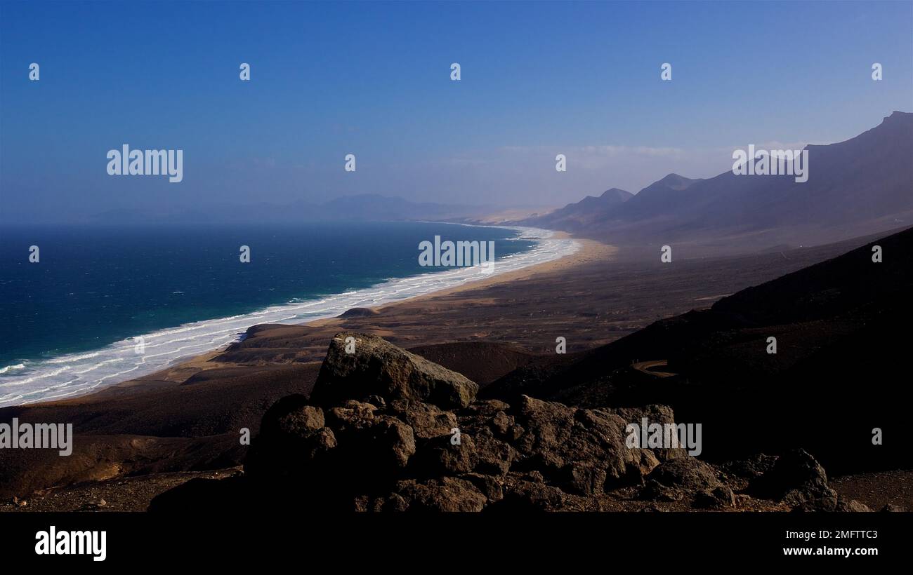 Sud sauvage, côte ouest, surf fort, chaîne de montagnes, paysage stérile, Ciel bleu, quelques nuages, Fuerteventura, Îles Canaries, Espagne Banque D'Images