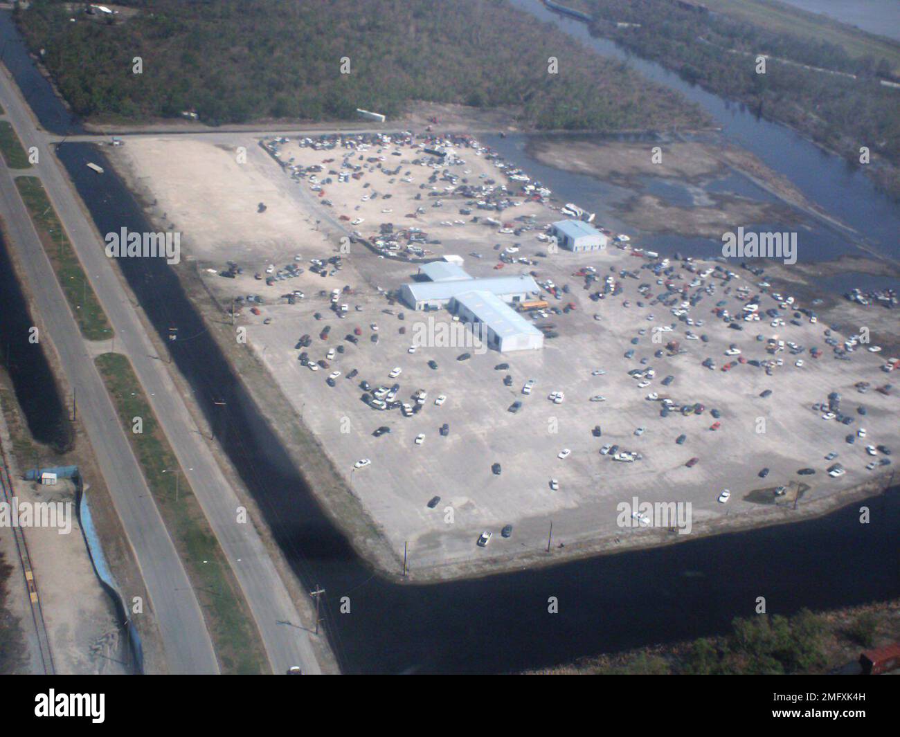 Séquelles - divers - 26-HK-48-162. grande vue aérienne du grand bâtiment en forme de croix avec parking rempli de véhicules déplacés. Ouragan Katrina Banque D'Images