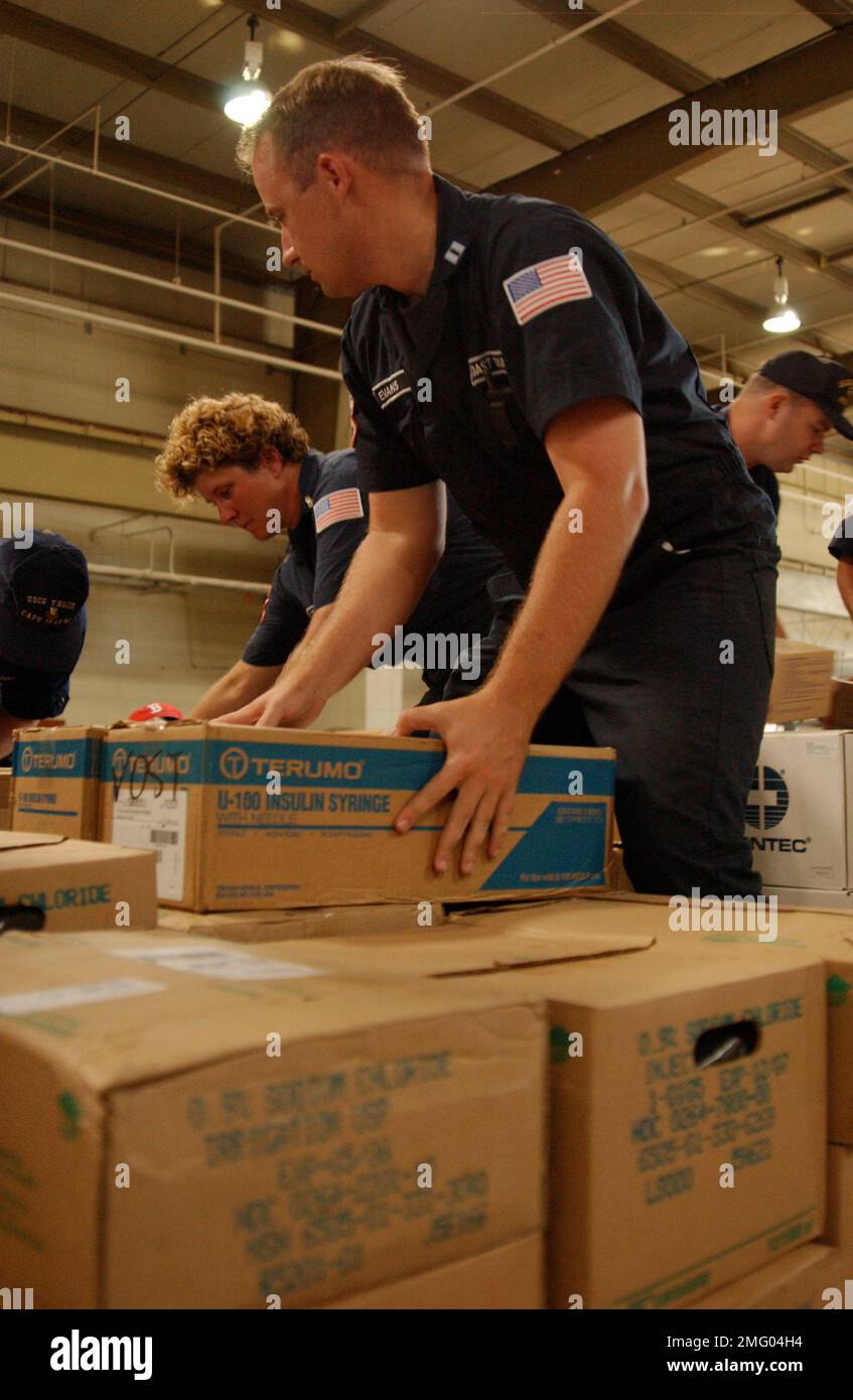 Personnel de la Garde côtière - fournitures - 26-HK-84-49. Personnel de CG avec fournitures -- membres de CG NSF soulevant des boîtes dans la zone de stockage-- 050901. Ouragan Katrina Banque D'Images