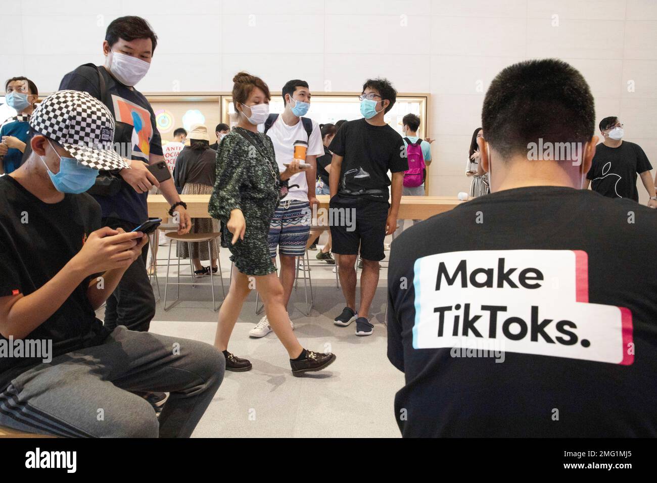 In this July 17, 2020, file photo, a visitor to an Apple store wears a t-shirt promoting Tik Tok in Beijing. TikTok executives told a Senate committee on Friday, Sept. 25, 2020, that they lobbied Australian lawmakers but did not engage with investigators before the government concluded that the video-sharing app did not pose a security threat. (AP Photo/Ng Han Guan, File) Banque D'Images