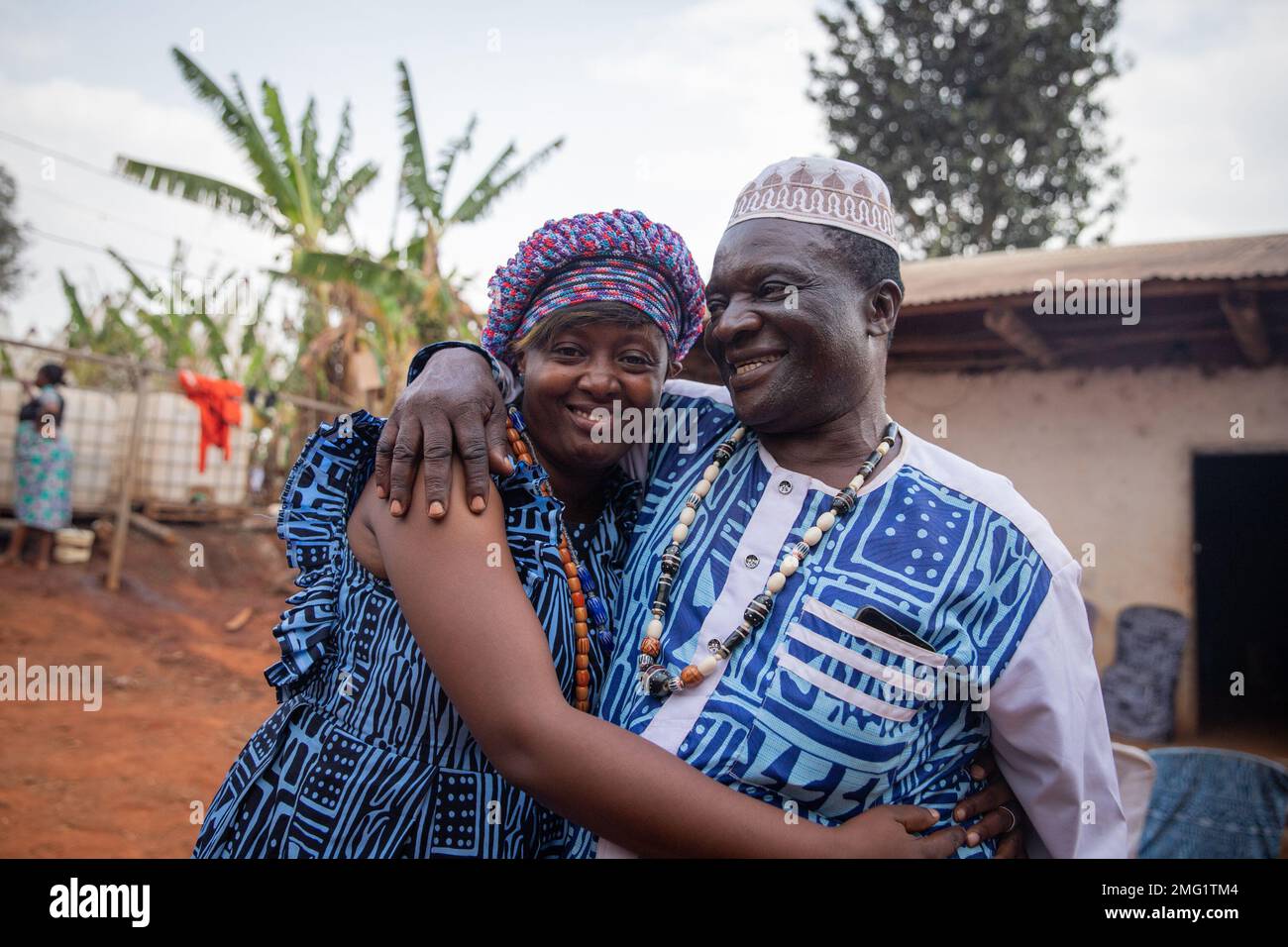 Deux Africains portant des vêtements traditionnels se embrassent lors d'une célébration au village Banque D'Images