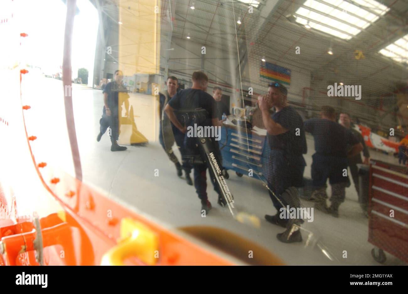 Structures de la Garde côtière - stations aériennes - opérations - 26-HK-96-74. AIRTSTA OPS--le personnel de la Garde côtière dans le hangar se reflète dans la fenêtre helo (2). Ouragan Katrina Banque D'Images
