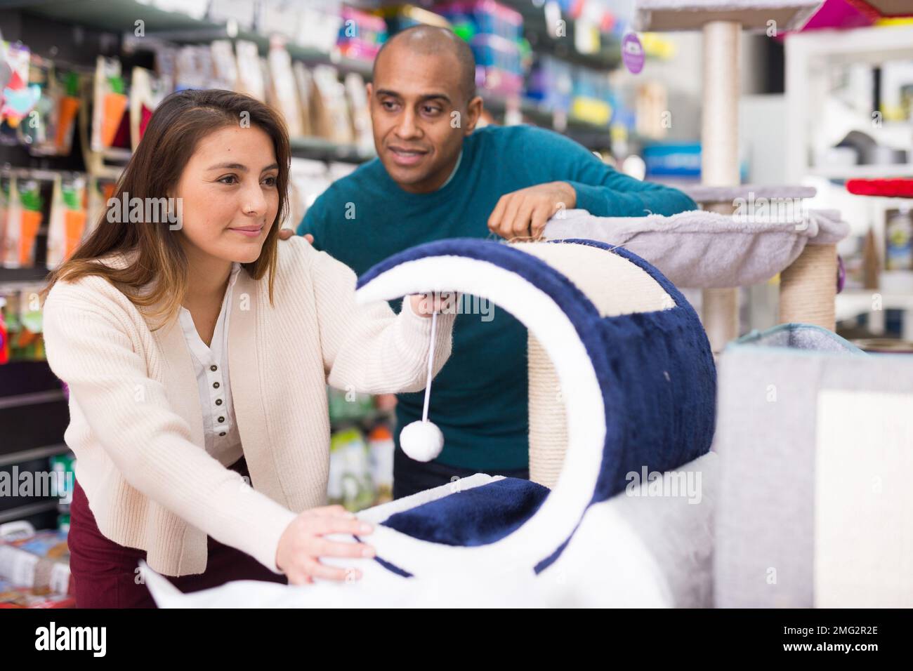 Couple choisissant des fournitures de meubles de chat en magasin Banque D'Images