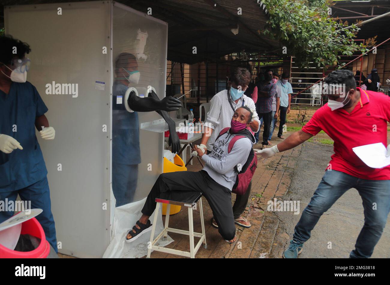 A man reacts as health workers help collect a nasal swab sample to test for COVID-19 in Hyderabad, India, Thursday, Sept. 17, 2020. As India’s coronavirus confirmed cases jump by a record 97,894 cases in the past 24 hours, Prime Minister Narendra Modi’s government faced a scathing opposition criticism in Parliament for its handling of the pandemic and a contracting economy leaving millions jobless on Thursday. (AP Photo/Mahesh Kumar A.) Banque D'Images