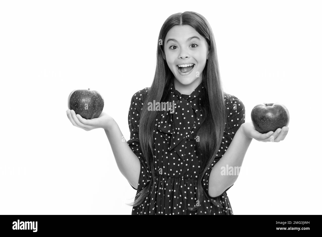 Adolescente fille mordre une pomme verte savoureuse. Portrait d'une jeune fille excitée et émotive. Banque D'Images