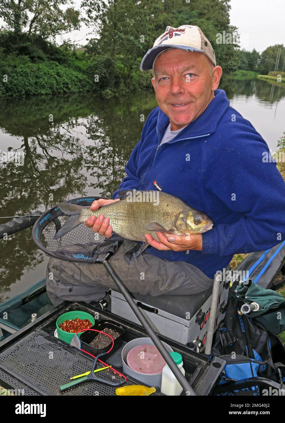 Pêcheur tenant sa prise, sur le canal de Bridgewater, Grappenhall, Warrington, Cheshire, Angleterre, ROYAUME-UNI, WA4 3EL Banque D'Images