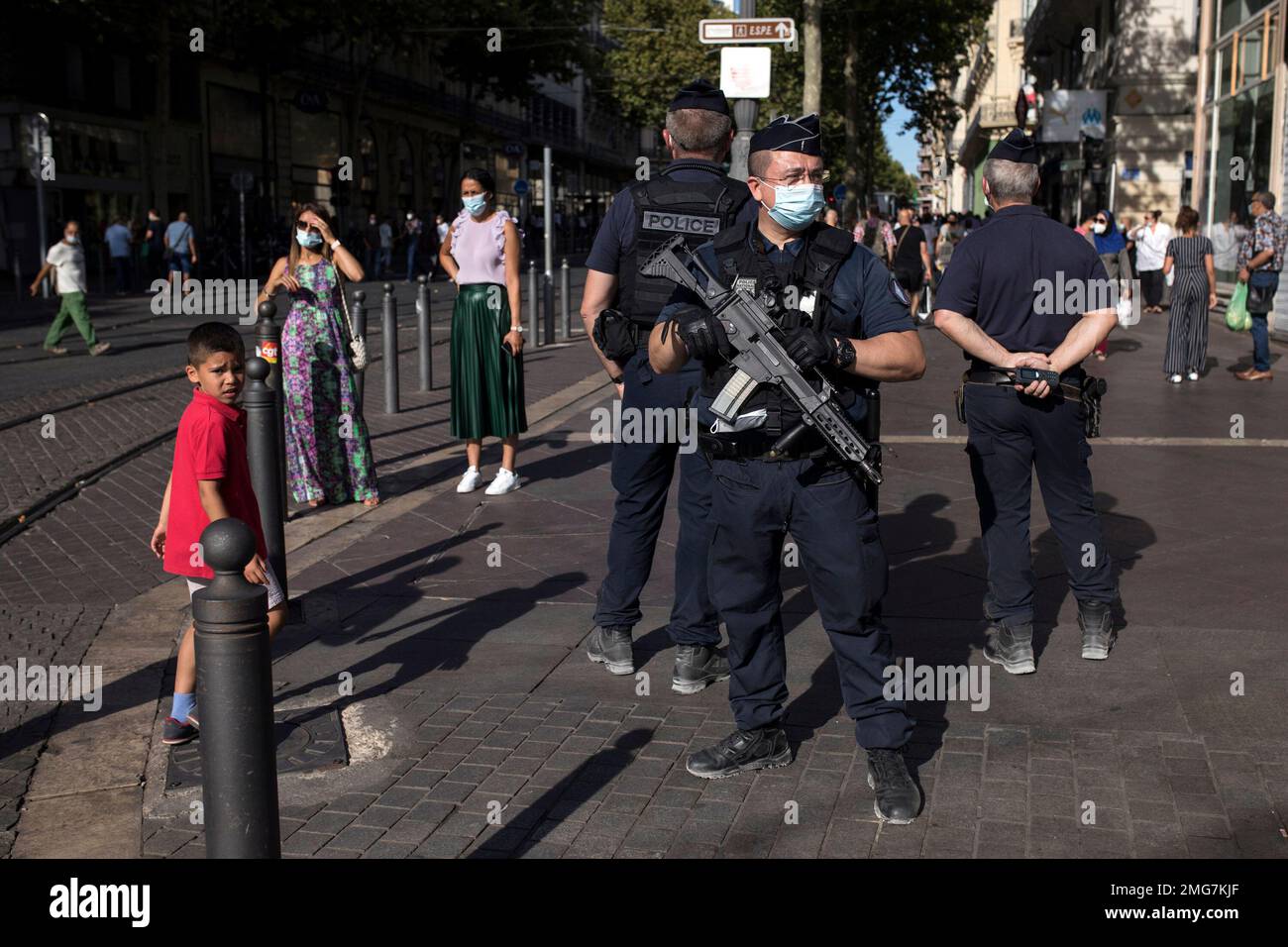 Riot police officers watch residents wearing face masks in Marseille, southern France, Tuesday, Aug.18, 2020. The French government is sending riot police to the Marseille region to help enforce mask requirements, as more and more French towns and neighborhoods are imposing mask rules starting Monday to slow rising infections. (AP Photo/Daniel Cole) Banque D'Images