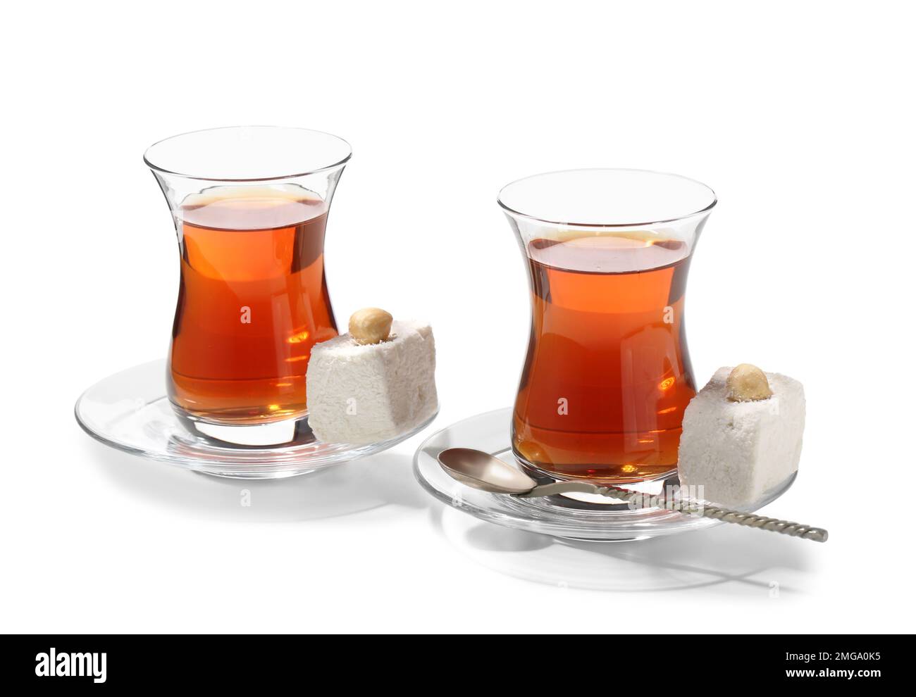 Tasses en verre de thé turc et bonbons sur fond blanc Banque D'Images