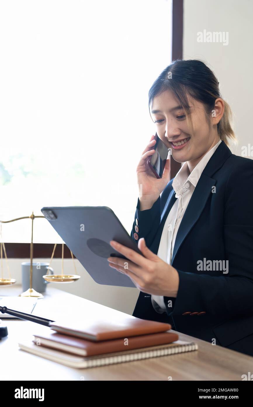 Jeune avocat attirante au bureau une femme d'affaires et des avocats appellent le téléphone au bureau. Droit, services juridiques, conseils, justice et concept immobilier Banque D'Images