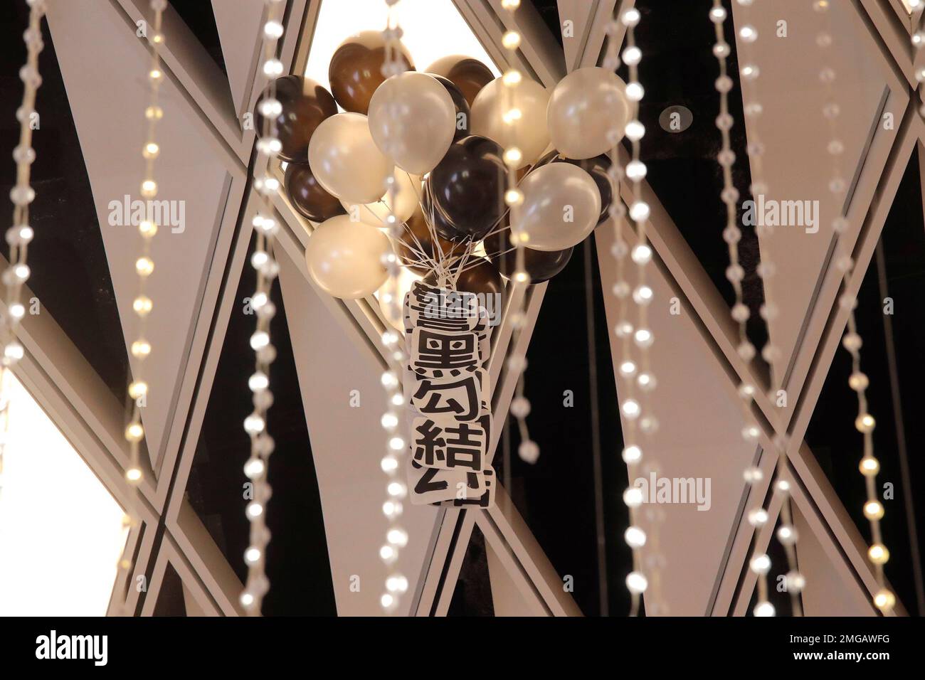 Balloons with banner are displayed by protesters during a pro-democracy protest to mark one-year anniversary of the Yuen Long subway attack, at a shopping mall in Hong Kong, Tuesday, July 21, 2020. A gang of men in white shirts brutally beat dozens of people inside the train station on July 21 last year. The banner read "Collusion between police and triads." (AP Photo/Kin Cheung) Banque D'Images
