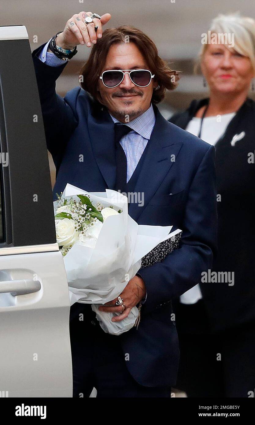 US Actor Johnny Depp waves as he leaves the High Court in London, Tuesday, July 14, 2020. Actor Johnny Depp is suing News Group Newspapers, publisher of The Sun, and the paper's executive editor, Dan Wootton, over an April 2018 article that called him a "wife-beater." The Sun's defense relies on allegations by Heard of Depp's violence, that he strongly denies. (AP Photo/Frank Augstein) Banque D'Images