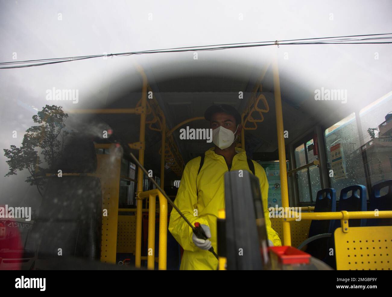 A Nepalese bus driver disinfects his vehicle before starting service in Kathmandu, Nepal, Tuesday, July 14, 2020. After restrictions on public transportation for almost four month to control the spread of the new coronavirus, Nepal's government has allowed public vehicles to operate within certain districts and inside Kathmandu valley, following safety norms. (AP Photo/Niranjan Shrestha) Banque D'Images