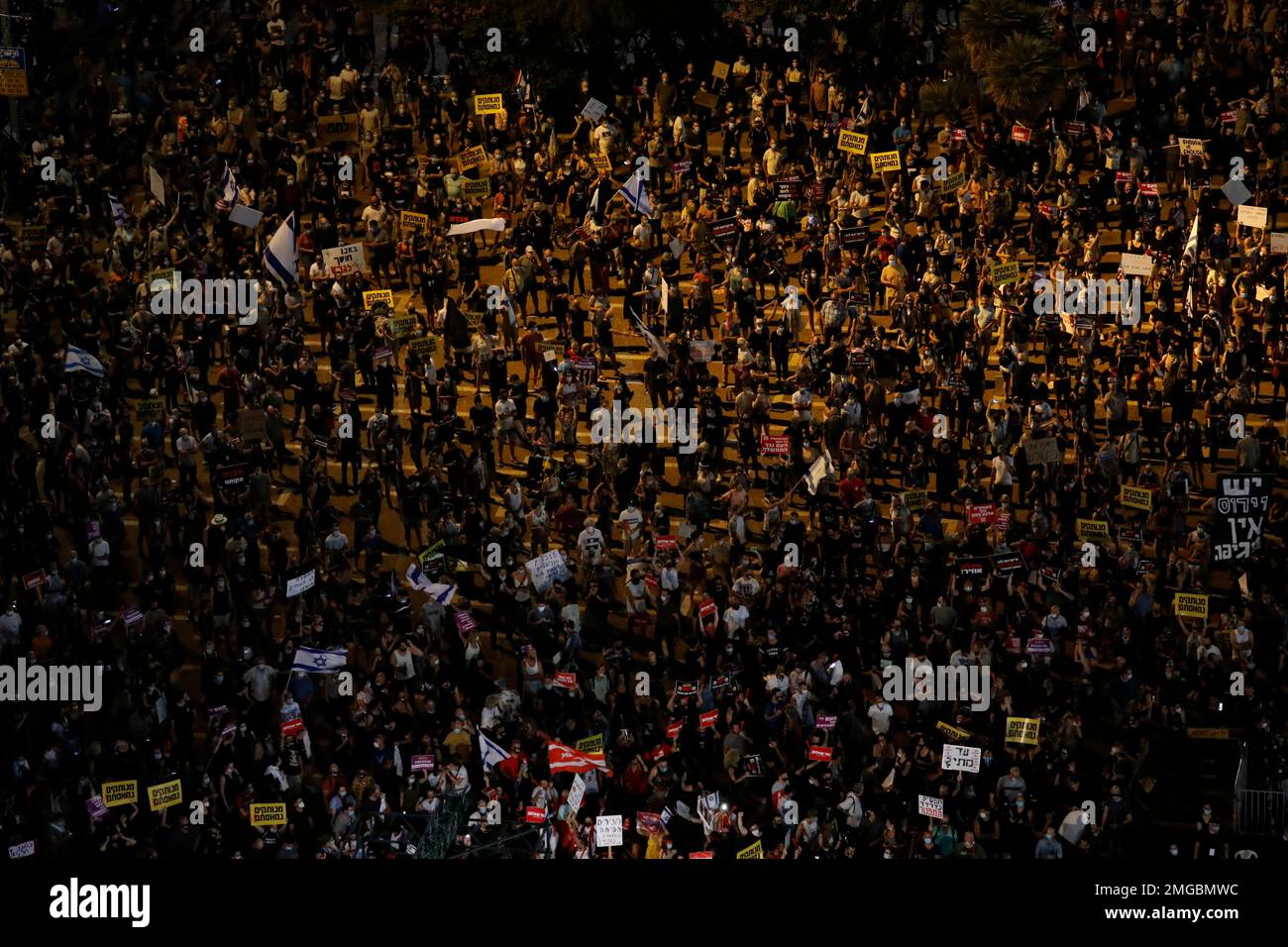 Protesters hold signs during a demonstration against Israel's government in Rabin square in Tel Aviv, Israel, Saturday, July 11, 2020. Thousands of Israelis gathered Saturday to protest the new government's failure to address economic woes brought by the coronavirus, directing their anger at Prime Minister Benjamin Netanyahu who is seeing his support plummeting. (AP Photo/Ariel Schalit) Banque D'Images