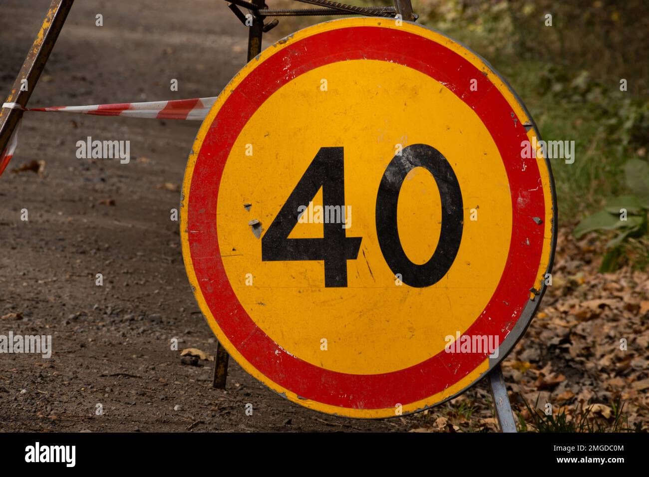 Panneau de limite de vitesse en raison d'un travail sur route indiquant une vitesse maximale de 40 kilomètres par heure. Tournez le panneau de signalisation au sol. Banque D'Images