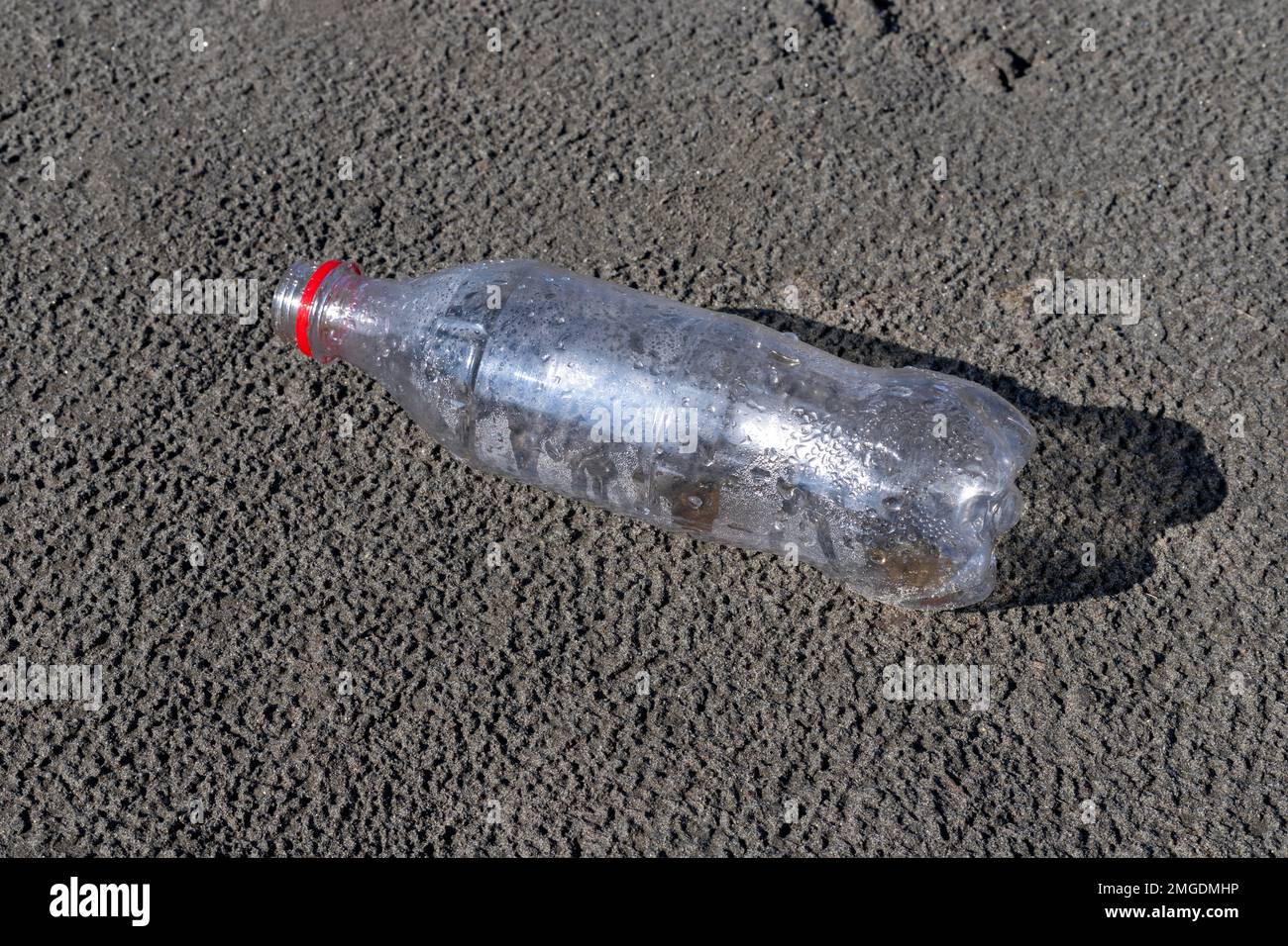Bouteille vide en plastique jetée sur une plage Banque D'Images Bouteille vide en plastique jetée sur une plage Banque D'Images