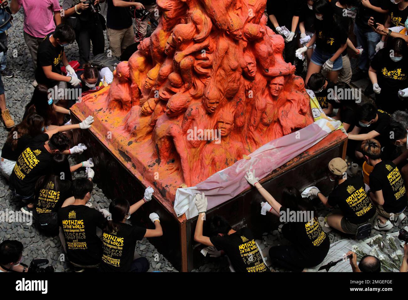 University students clean the "Pillar of Shame" statue, a memorial for those killed in the 1989 Tiananmen crackdown, at the University of Hong Kong, Thursday, June 4, 2020. China is tightening controls over dissidents while pro-democracy activists in Hong Kong and elsewhere try to mark the 31st anniversary of the crushing of the pro-democracy movement in Beijing's Tiananmen Square. (AP Photo/Kin Cheung) Banque D'Images