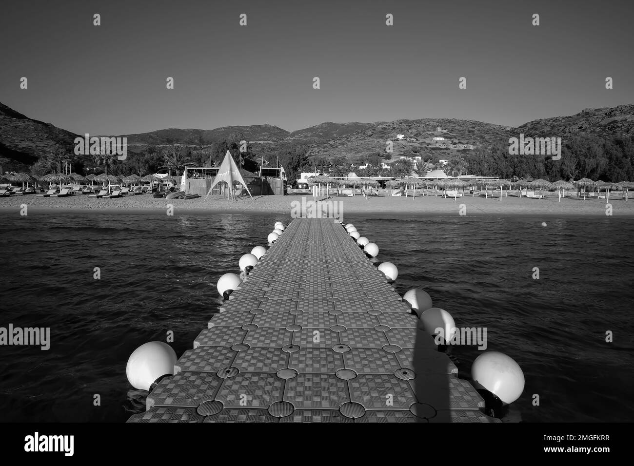 IOS, Grèce - 3 juin 2021 : vue d'un quai flottant, également connu comme un pont flottant à la plage Mylopotas dans iOS Grèce en noir et blanc Banque D'Images