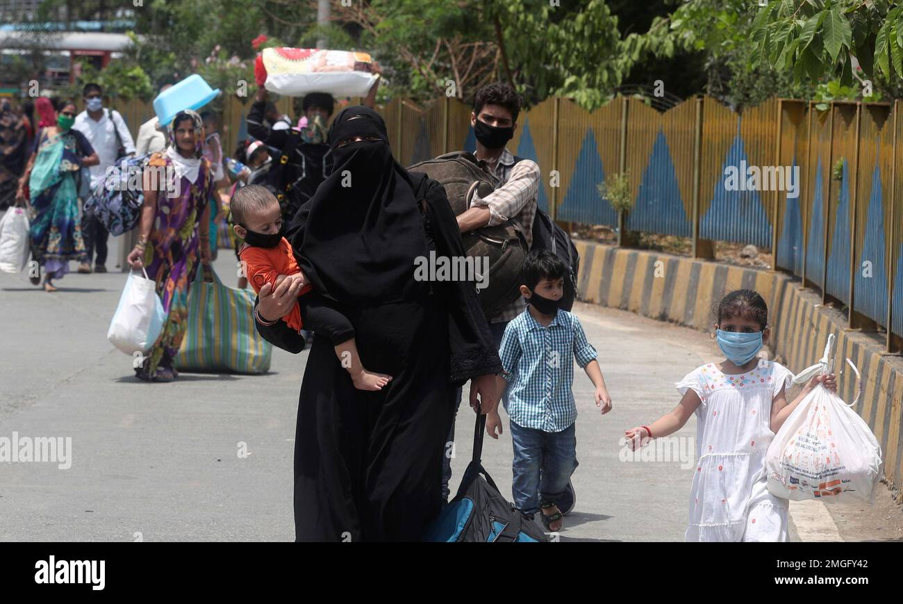 Migrant workers and their families arrive outside a railway station to catch a train to return to their home states, in Mumbai, India, Wednesday, May 20, 2020. The pandemic has exposed India's deep economic divide as millions of migrant workers have left Indian cities with luggage bags perched on their heads and children in their arms, walking down highways in desperate attempts to reach the countryside. (AP Photo/Rafiq Maqbool) Banque D'Images