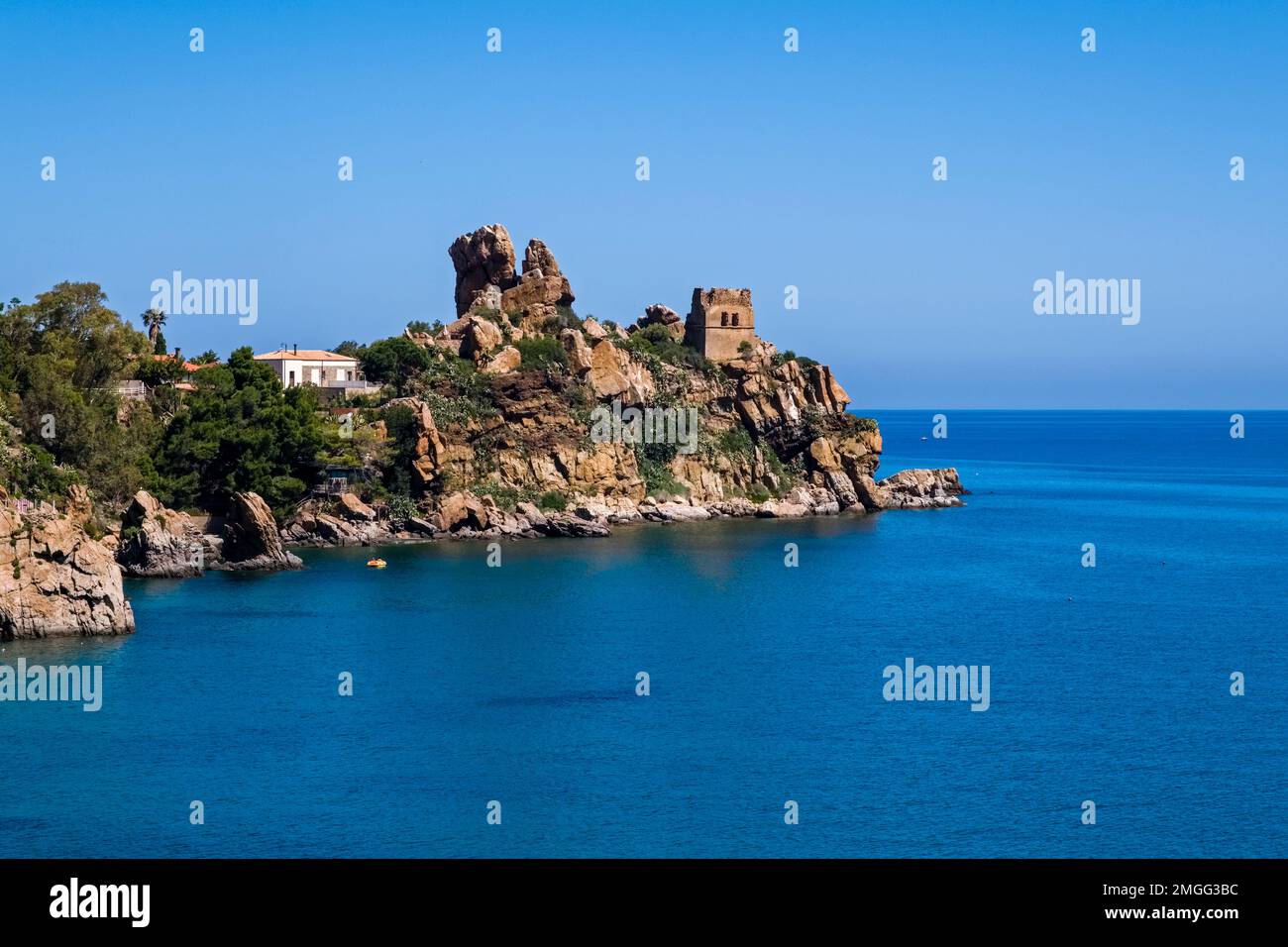 Une petite péninsule avec les ruines d'un vieux château dépasse dans la mer en dehors de la ville médiévale de Cefalu. Banque D'Images