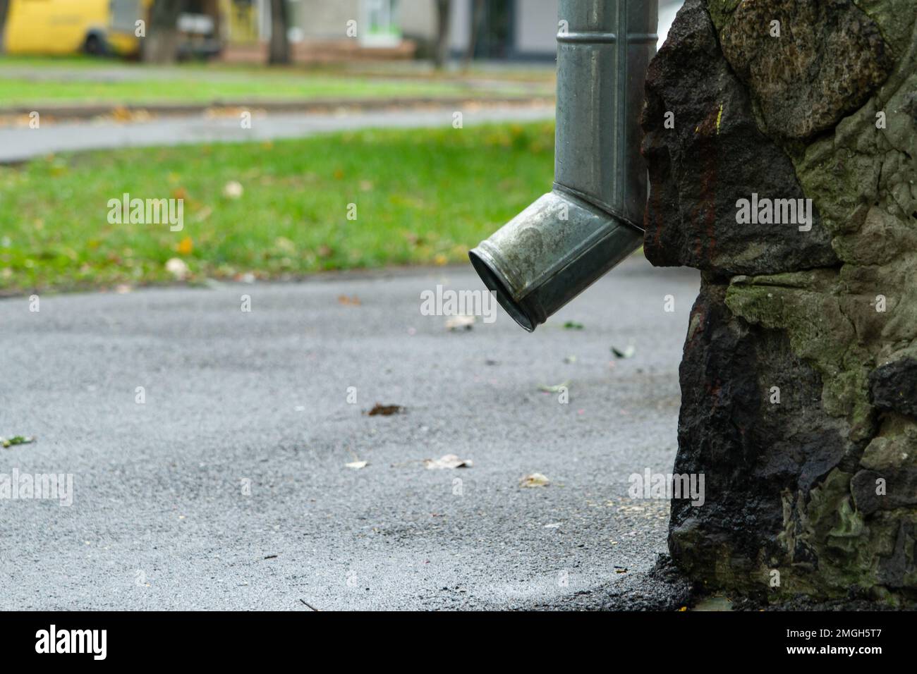 Descente de gouttière près du côté d'une maison, vue latérale. Bas de la goulotte de descente. Banque D'Images