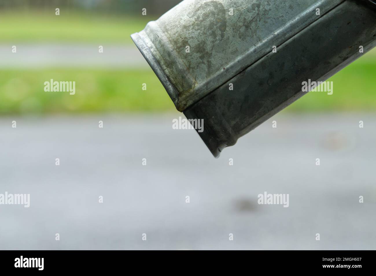 Gros plan des tuyaux d'évacuation et du trottoir en asphalte. Bas de la goulotte de descente. Banque D'Images