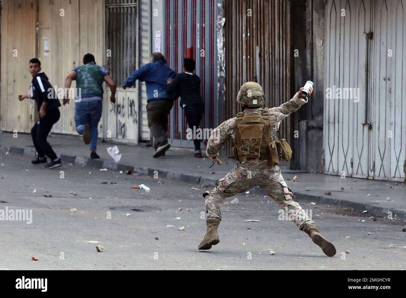 A Lebanese army soldier throws a tear gas canister towards anti-government protesters in the northern city of Tripoli, Lebanon, Tuesday, April 28, 2020. Hundreds took part in the funeral of a young man killed in riots overnight in Tripoli that were triggered by the crash of Lebanon's national currency that sent food prices soaring. (AP Photo/Bilal Hussein) Banque D'Images