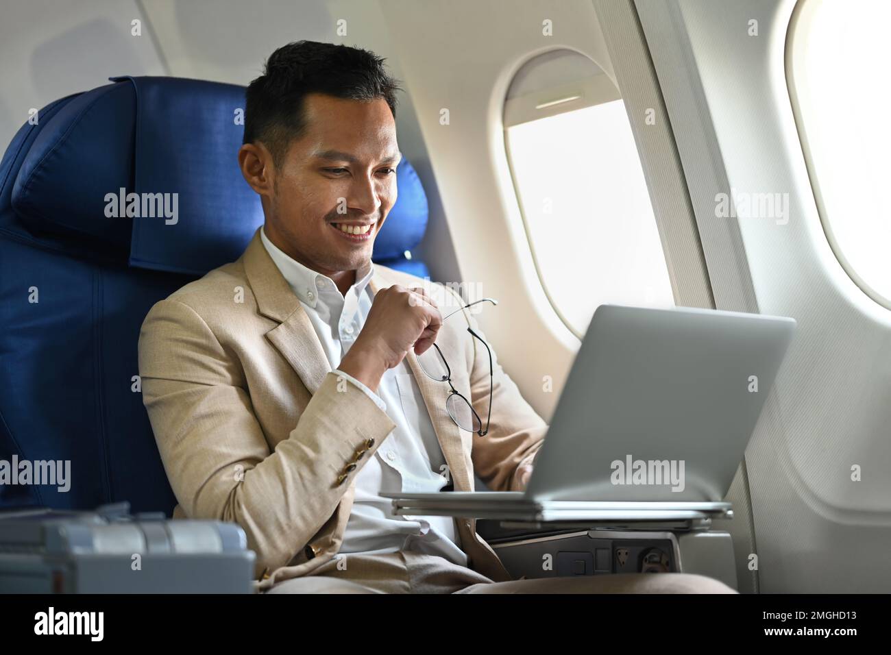 Homme d'affaires réussi en costume de luxe élégant travaillant avec un ordinateur portable dans l'avion pendant les voyages d'affaires Banque D'Images