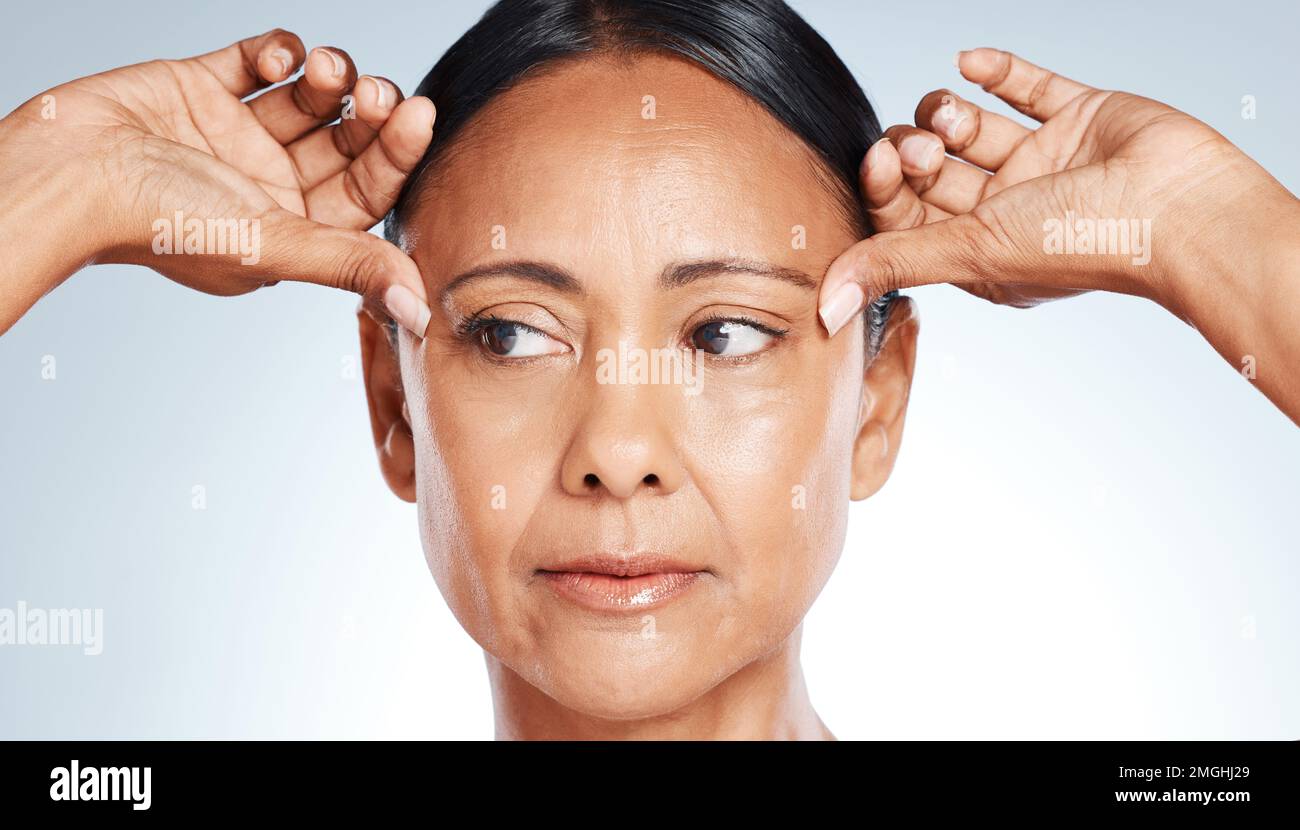 Soins de la peau, beauté et femme âgée pensant à des rides isolées sur un fond gris studio. Souci, cosmétique et visage d'un modèle mature sensation de peau Banque D'Images
