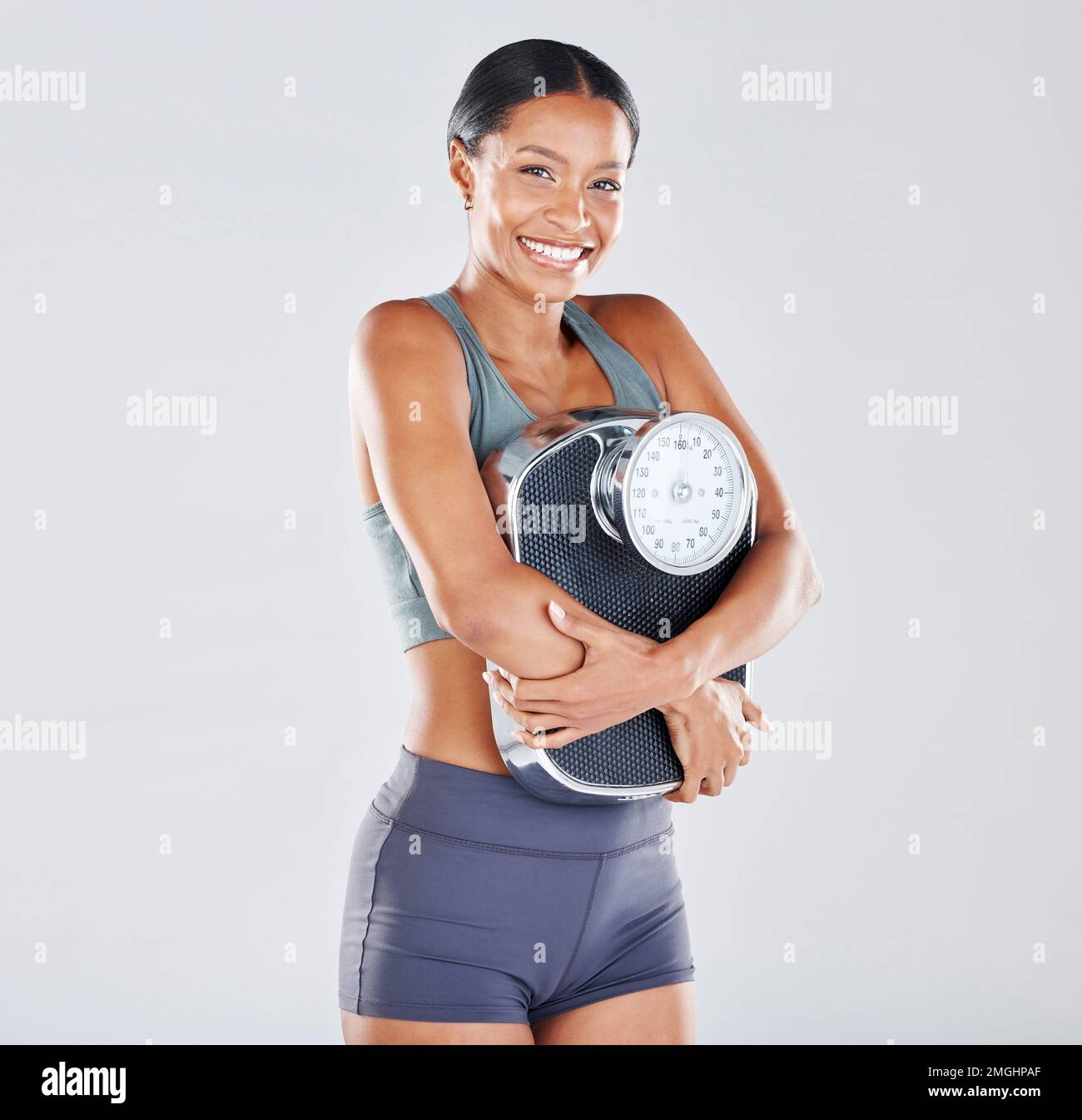 Régime, portrait et échelle avec une femme noire athlète en studio sur fond gris pour la positivité ou la santé du corps. Fitness, perte de poids et perte Banque D'Images