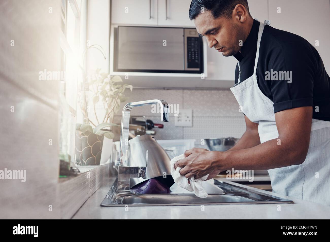 Nettoyage de la cuisine, lavage de la vaisselle et un homme dans la maison, la maison ou l'appartement pour nettoyer pour la sécurité des bactéries. Homme nettoyant personne à l'évier avec un chiffon dedans Banque D'Images