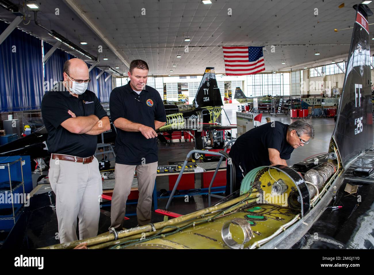 Robert Pilarczyk (à gauche), Hill Engineering, et Larry Hall (au centre), 809th, Escadron de maintenance des aéronefs, technicien en inspection non destructive, examine un T-38, comme Oscar Almeida (à droite), 575th, Escadron de maintenance des aéronefs, électricien, effectue la maintenance, le 24 août 2022, À la joint base San Antonio-Randolph, Texas. Tous font partie du programme d'inspection et d'entretien des réparations talon (TRIM). Le programme D'AJUSTEMENT sera exécuté sur 190 appareils T-38. Cette fonctionnalité permet une maintenance localisée au niveau du dépôt pour remplacer ou réparer les pièces clés. Banque D'Images