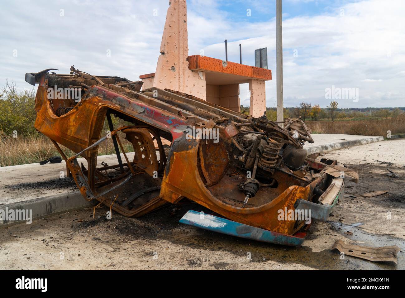 Campagne. Une voiture civile renversée et brûlée se trouve à une gare routière. La guerre en Ukraine. Invasion russe de l'Ukraine. Crimes de guerre Banque D'Images