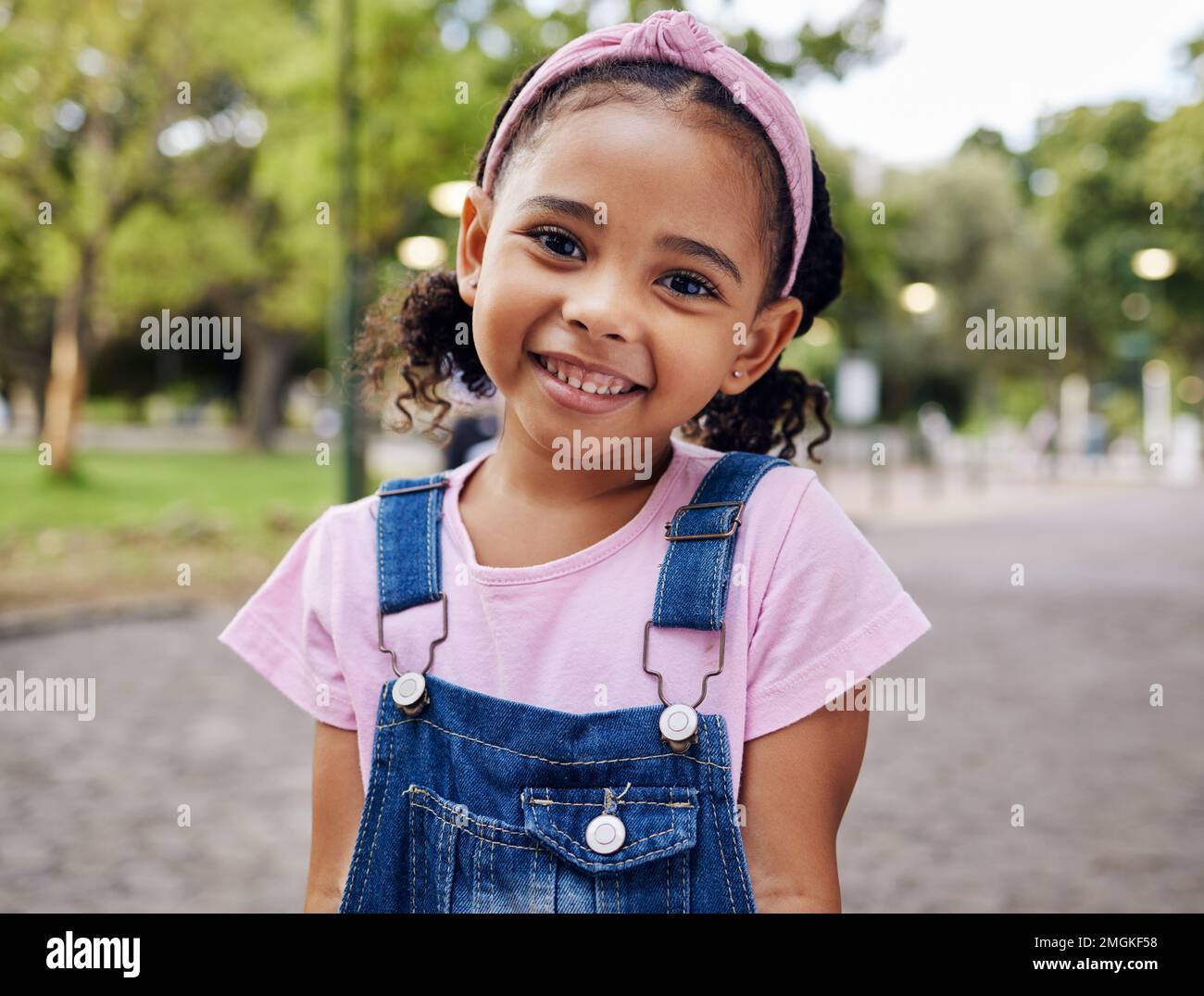 Portrait, jeune fille et sourire dans le parc, enfant heureux à l'extérieur avec la nature et la liberté avec l'état d'esprit positif. Voyage, bonheur et aventure, croissance et Banque D'Images