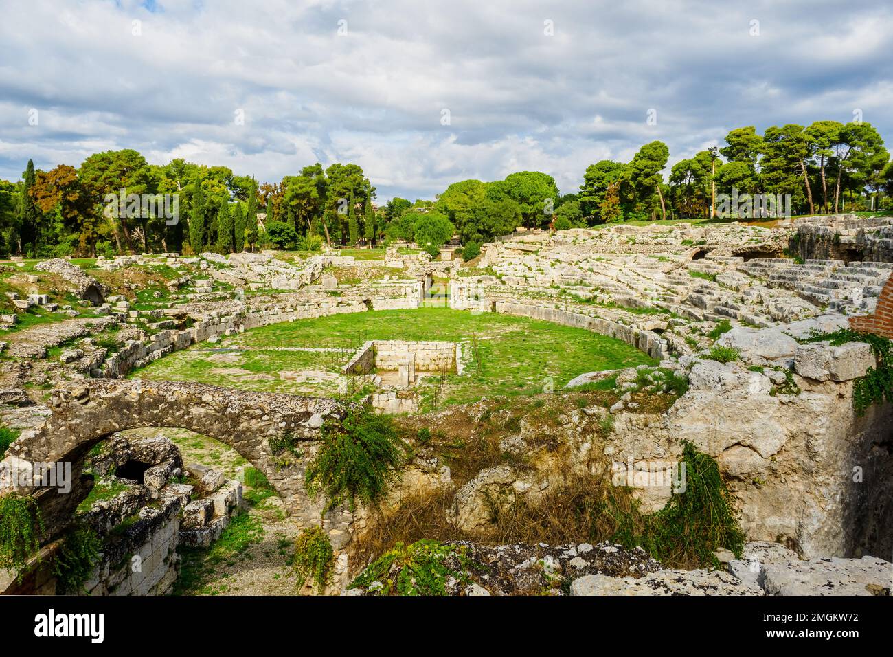 Amphithéâtre romain de Syracuse - I cent. AD - III cent. AD - Parc archéologique de Neapolis - Syracuse, Sicile, Italie l'amphithéâtre a deux entrées et est desservi par un système complexe d'escaliers qui descendent du niveau supérieur situé à l'extérieur. L'arène était équipée, au centre, d'une grande pièce rectangulaire, à l'origine couverte, reliée par un passage souterrain à l'extrémité sud du monument, sur l'axe du couloir d'entrée. Autour de l'arène, la cavea se distingue par un haut podium, derrière lequel s'étend un couloir couvert avec des portes d'accès à l'arène pour les gladiateurs A. Banque D'Images