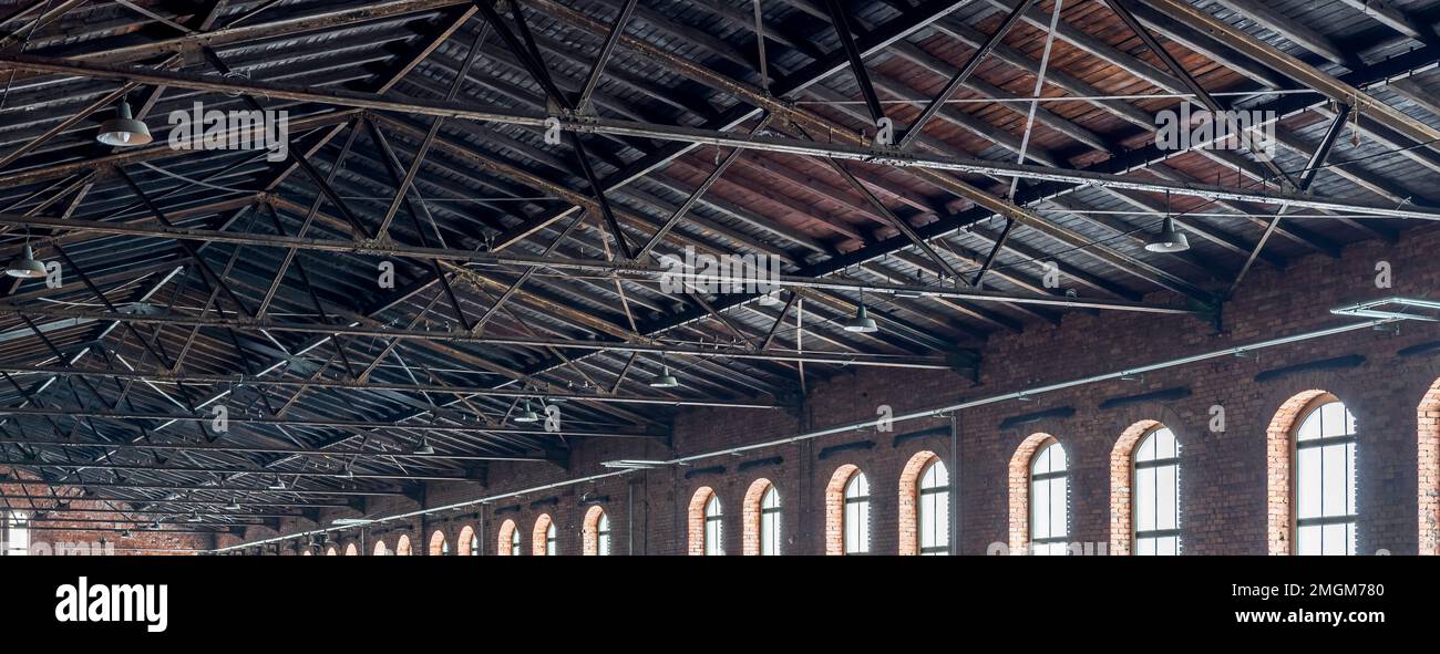 Toit en treillis d'un grand hall d'usine d'époque. Construction de toitures (gainage) en planches de bois. Murs de briques et fenêtres de jeux vidéo. Industriel Banque D'Images