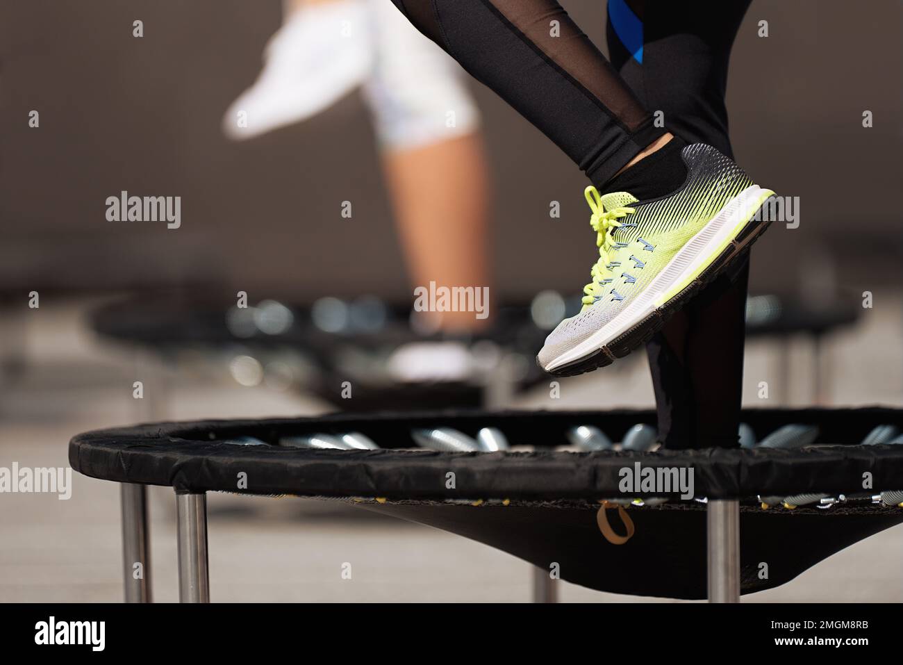 Les femmes de forme physique sautant sur de petits trampolines, de l'exercice sur le rétracteur Banque D'Images