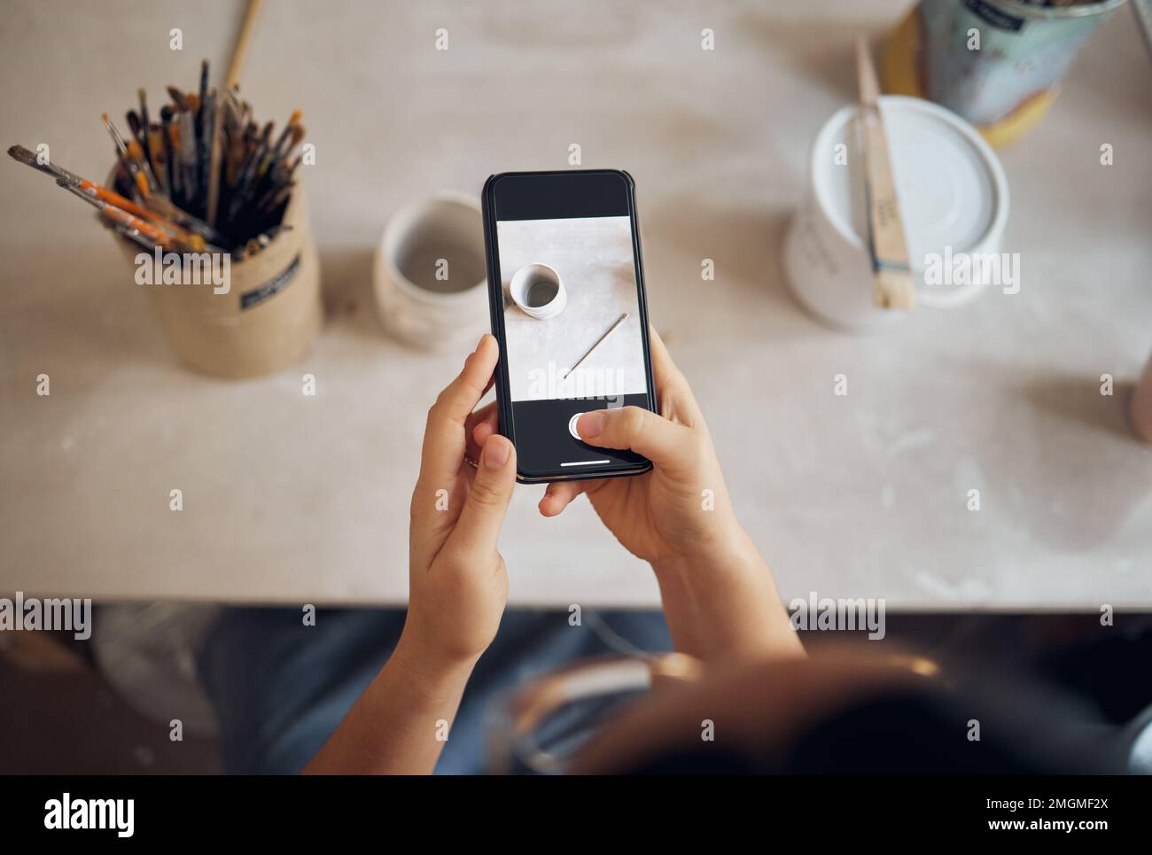Téléphone, poterie et mains Prenez des photos à l'écran pour les médias sociaux, les blogs et le site Web créatif pour les cours d'art. Atelier, smartphone et femme Banque D'Images