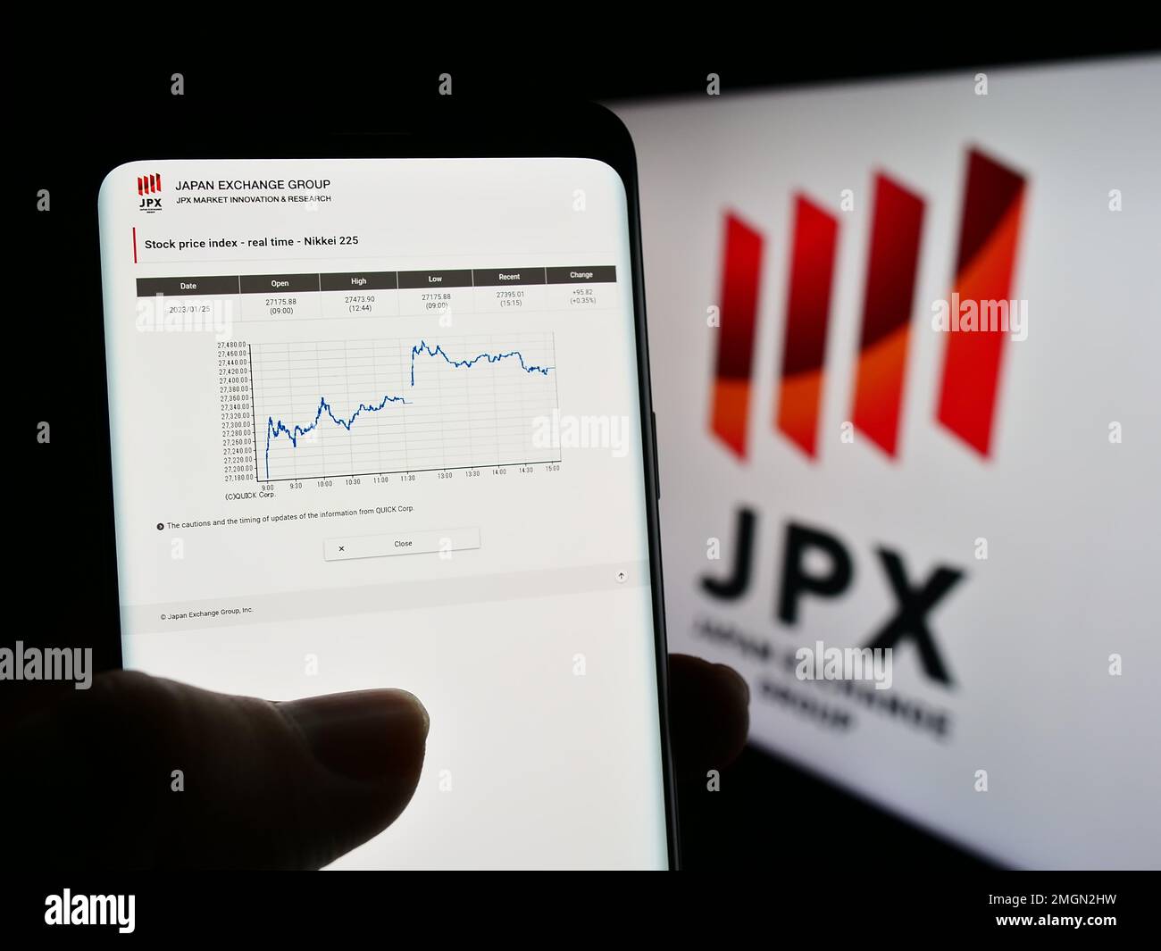 Personne détenant un téléphone portable avec le site Web de la société Japan Exchange Group Inc. (JPX) à l'écran devant le logo. Concentrez-vous sur le centre de l'écran du téléphone. Banque D'Images