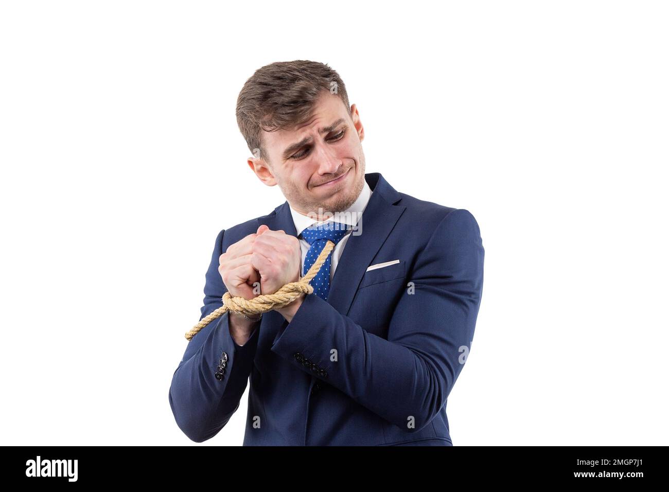 Le portrait d'un beau homme dans un costume avec les mains liées tente de se libérer. concept de dépendance financière et d'esclavage. Banque D'Images