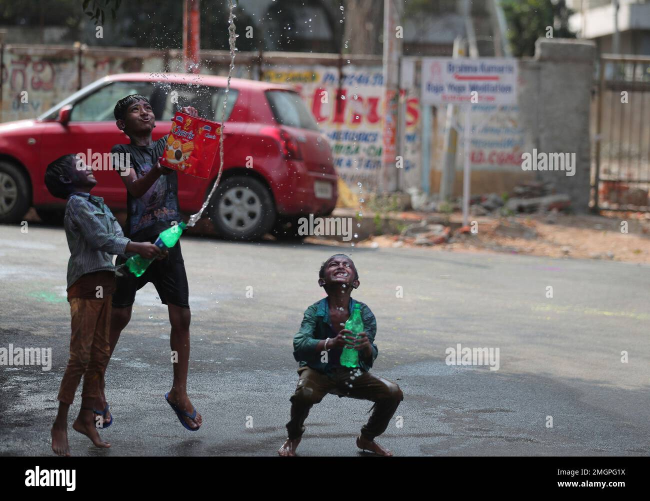 Indian children playing with water as they celebrate Holi festival in Hyderabad, India, Monday, March 9, 2020. Holi, the Hindu festival of colors, also heralds the coming of spring. (AP Photo/Mahesh Kumar A.) Banque D'Images