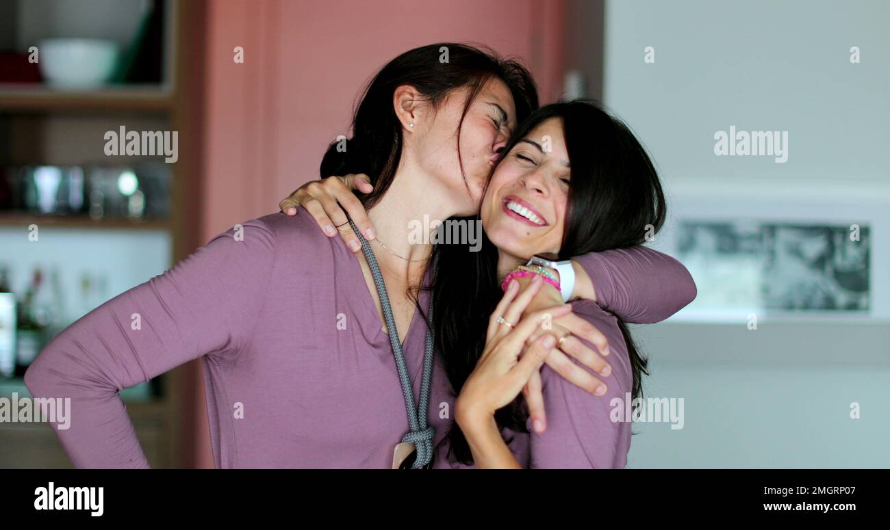 Les sœurs jumelles qui se posent ensemble deux femmes amis embrassent et aiment Banque D'Images