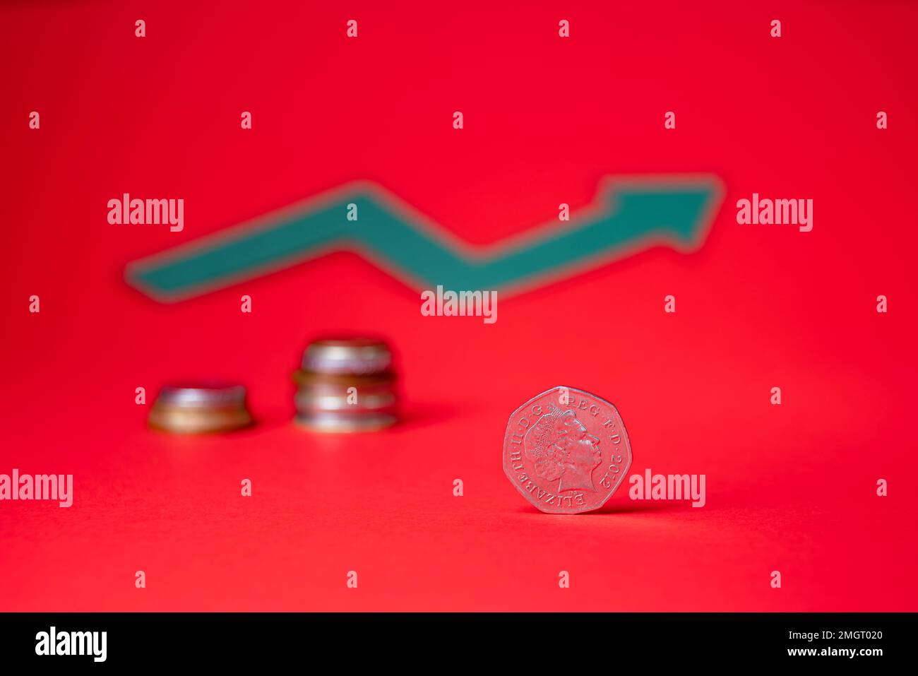 Argent anglais - cinquante pence sur fond rouge. Signe de croissance flou en arrière-plan. Des économies pour l'avenir. Banque D'Images