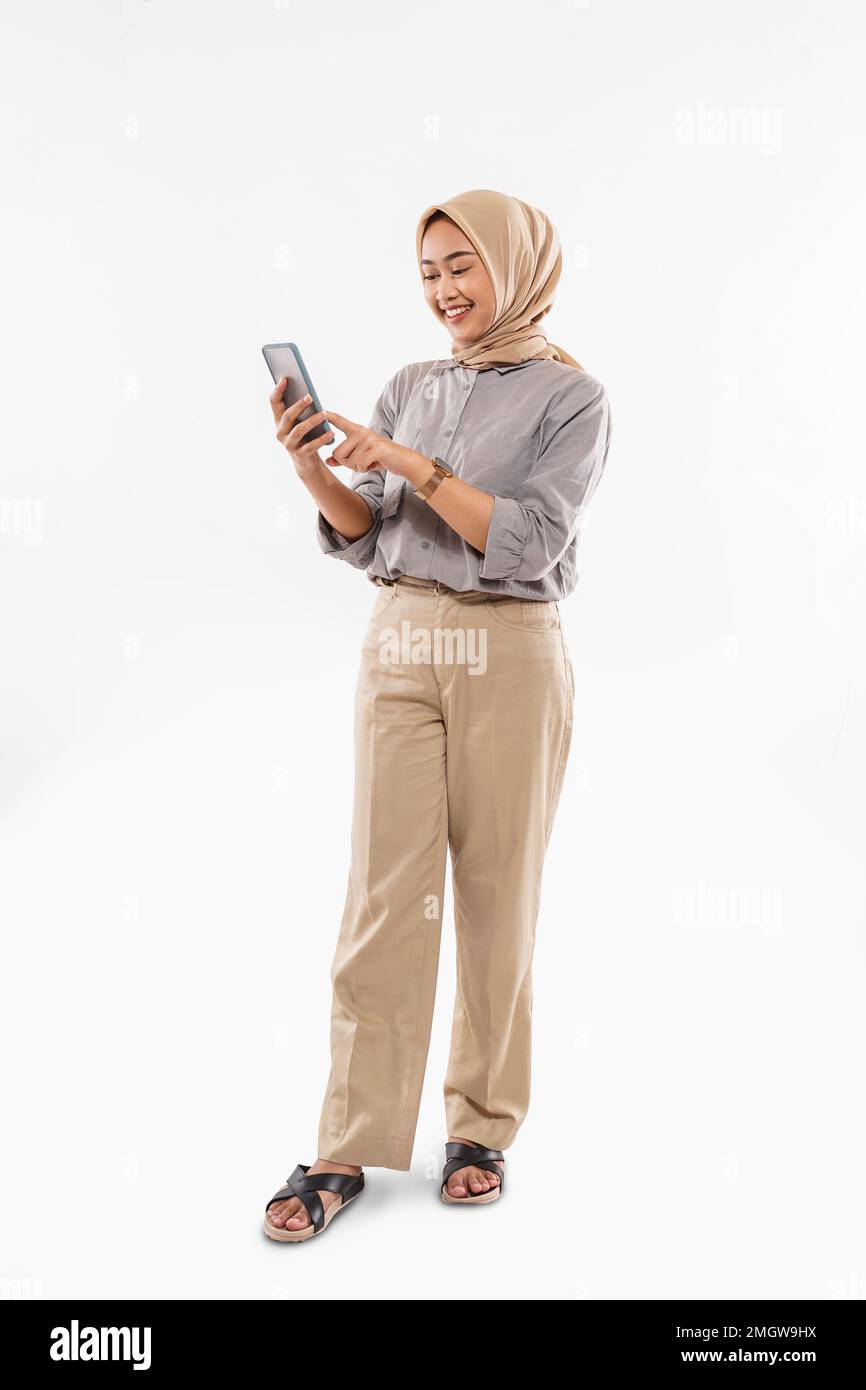 une belle femme avec hijab debout et pointant sur le téléphone Banque D'Images