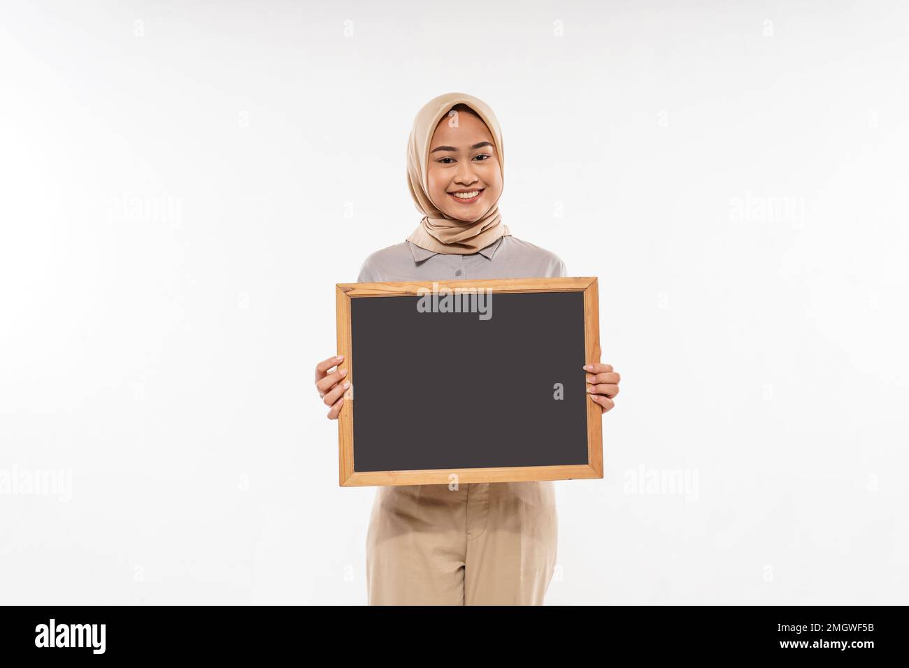 une femme avec hijab montrant le tableau noir devant son corps Banque D'Images