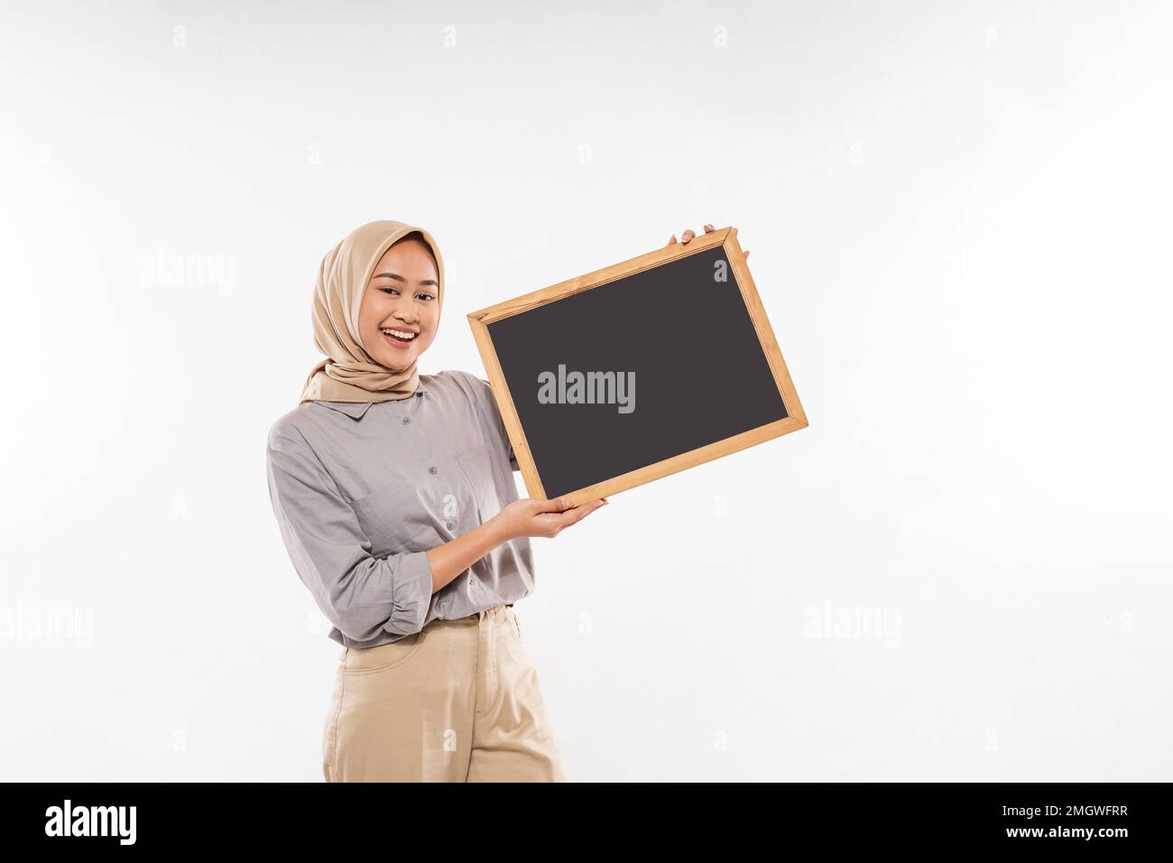 une belle femme avec hijab debout et montrant avec enthousiasme le tableau noir Banque D'Images