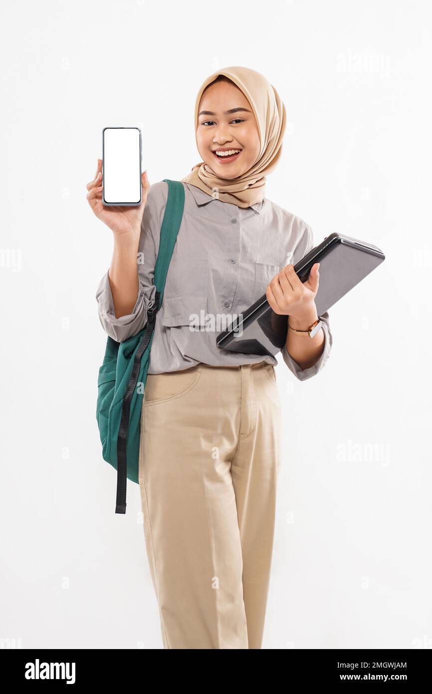 un bel étudiant avec hijab debout montrant le téléphone Banque D'Images