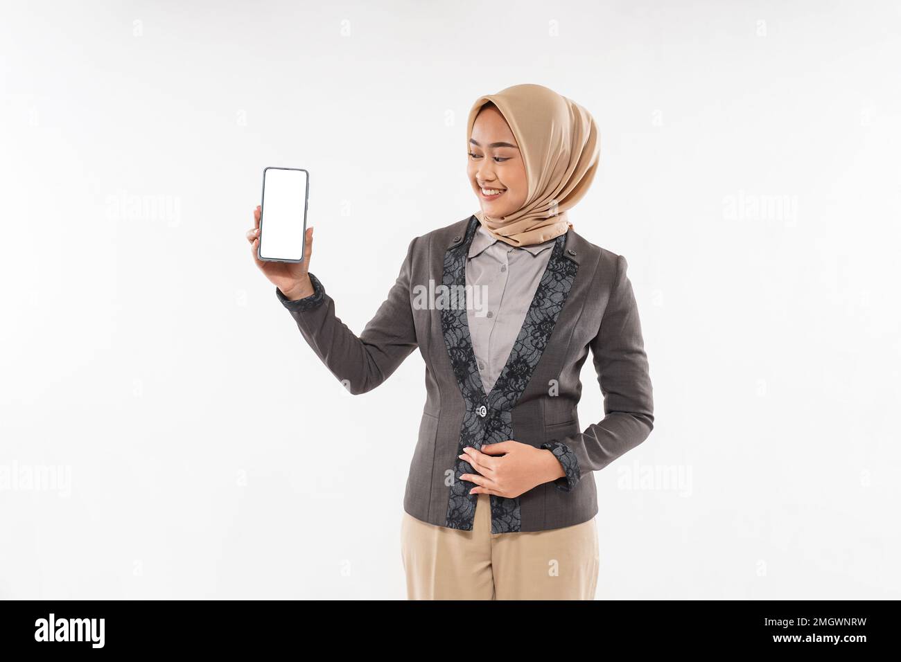 une femme avec hijab debout et montrant le téléphone à sa main Banque D'Images
