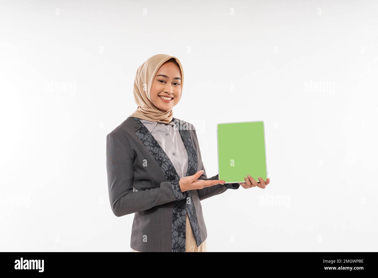 une femme avec hijab debout et montrant la tablette à sa main Banque D'Images