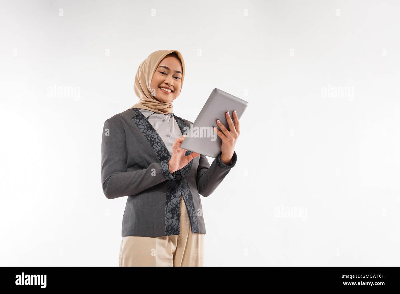 une femme avec hijab debout et apporter la tablette à sa main Banque D'Images